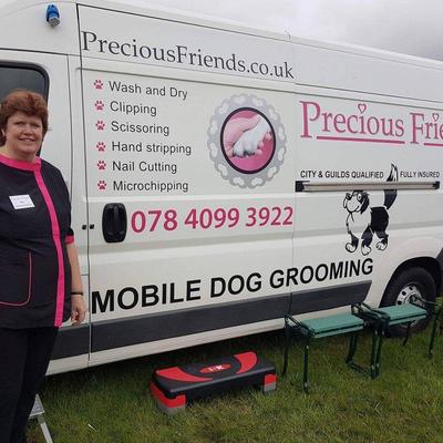 Small jan stands beside her mobile dog grooming van